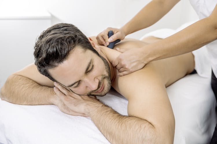 Eine Masseurin massiert einen Mann mit einem Massageball in der Tamina Therme in der Schweiz.