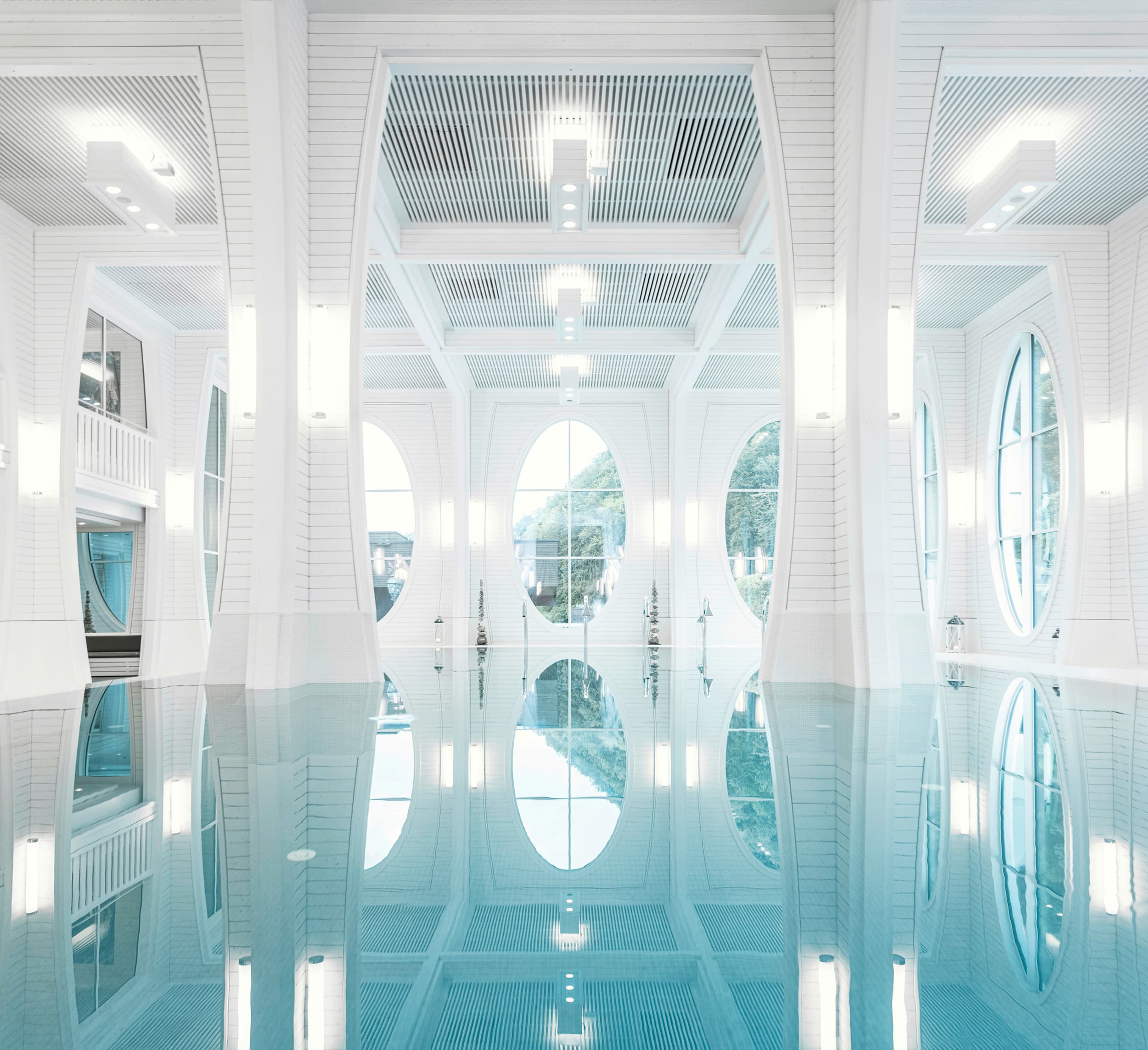 Innen Becken mit großen hellen Decken und türkisem Wasser im Thermalbad Bad Ragaz - Schweiz.