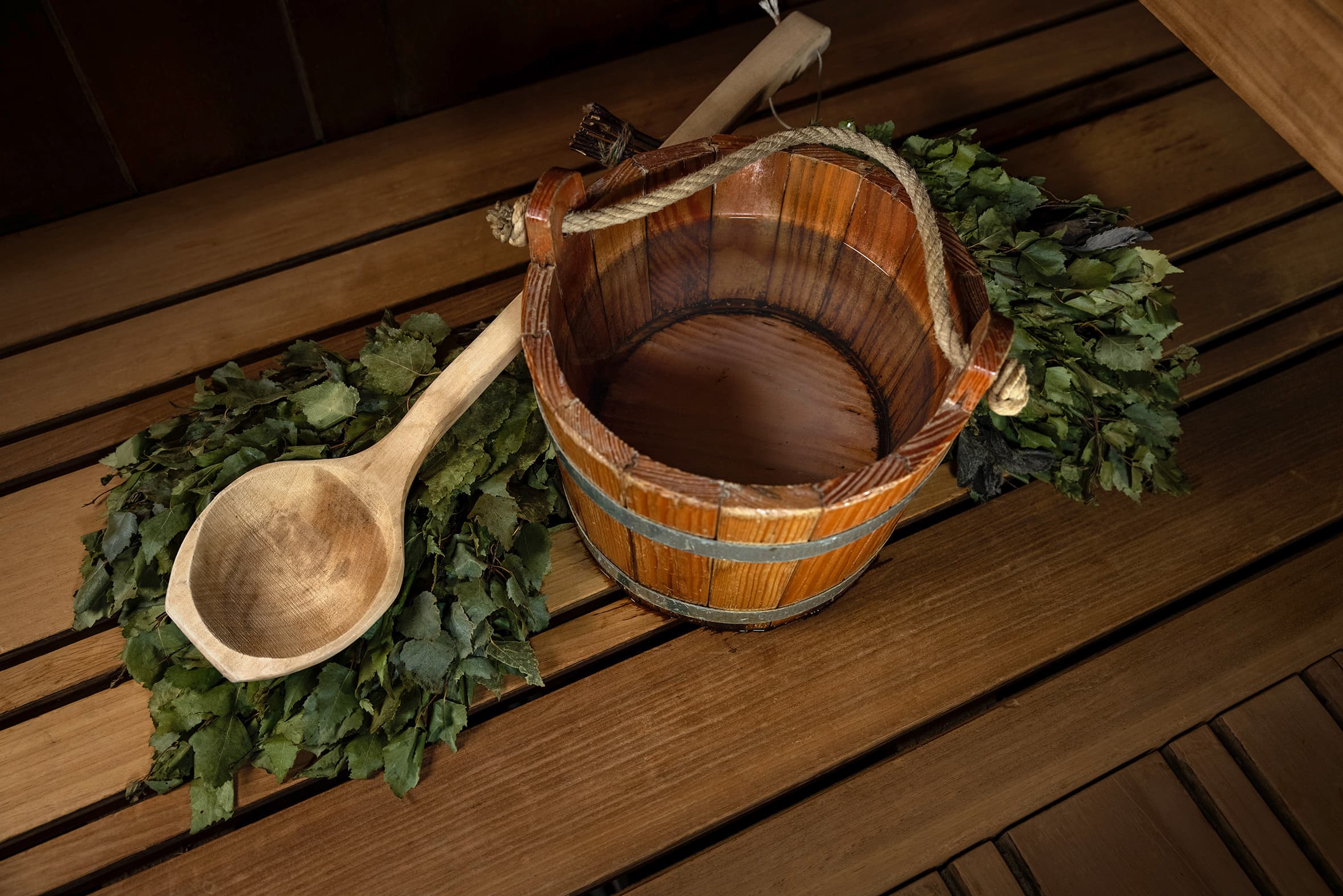 Detailaufnahme mehrerer Zweige und eines Wasserkessels mit Holzkessel in der besten Saunalandschaft der Schweiz.