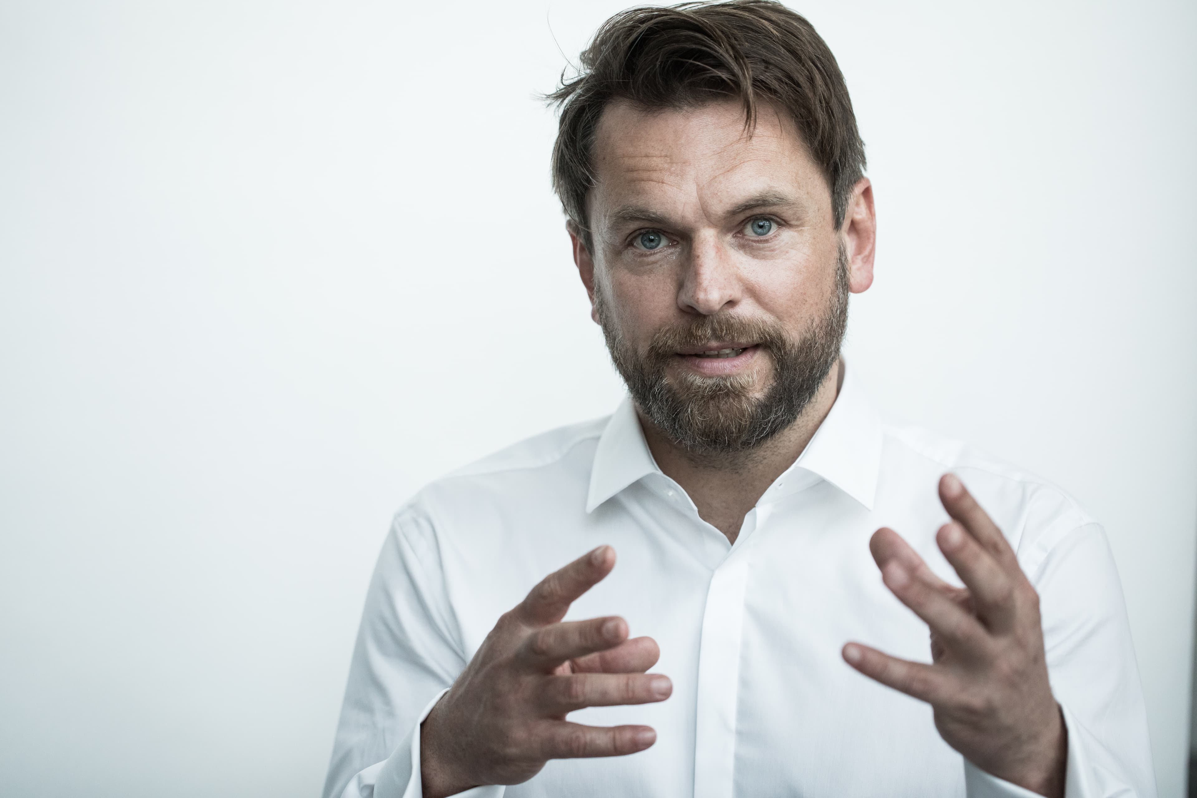 Ein Mann in einem weißen Hemd gestikuliert auffällig mit den Händen.