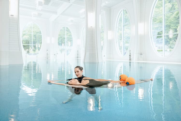 Eine Therapeutin übt mit einer Kundin das Floating im Innenpool der Tamina Therme in Bad Ragaz.