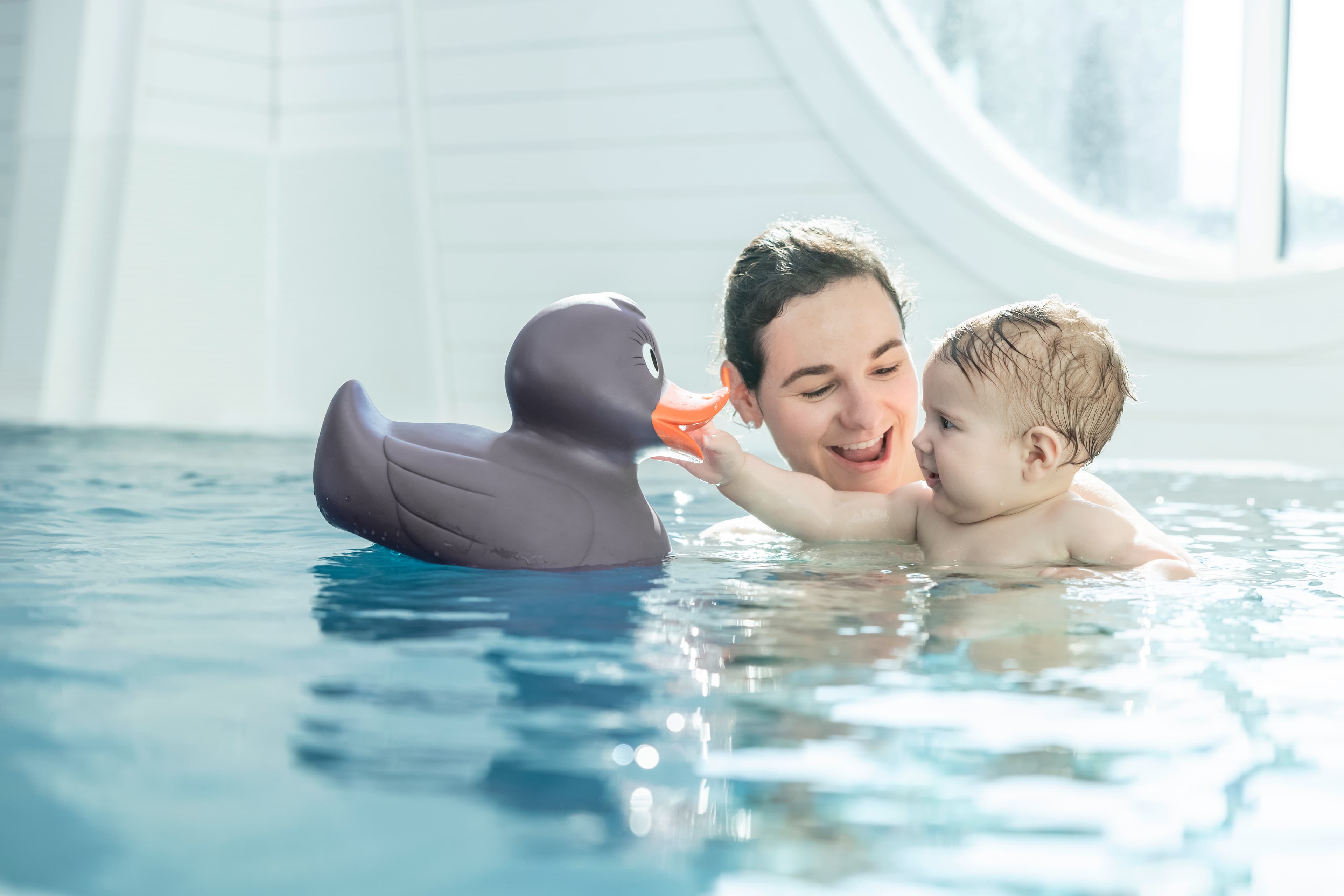 Mutter und Kind spielen mit einer Bade-Ente in der Tamina Therme in der Schweiz.