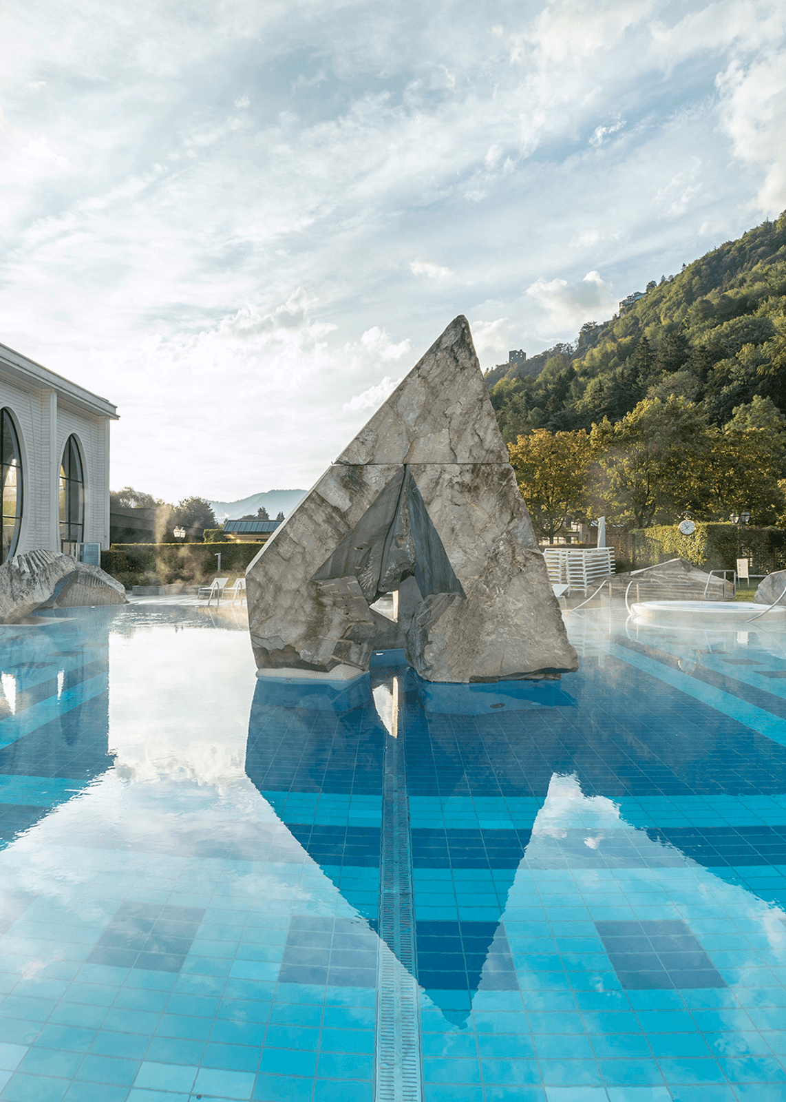 Blick auf einen Außenpool mit Steinfelsen in der Tamina Therme in Bad Ragaz.