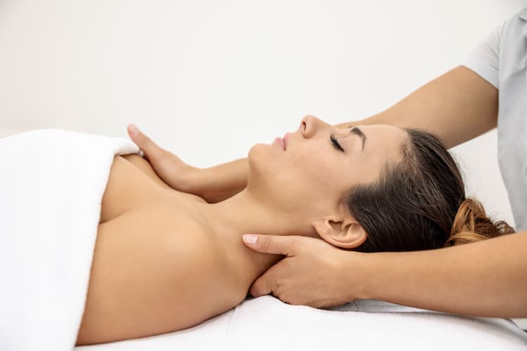 Eine Kundin erhält eine Nackenmassage in der Spa Welt der Tamina Therme in Bad Ragaz.