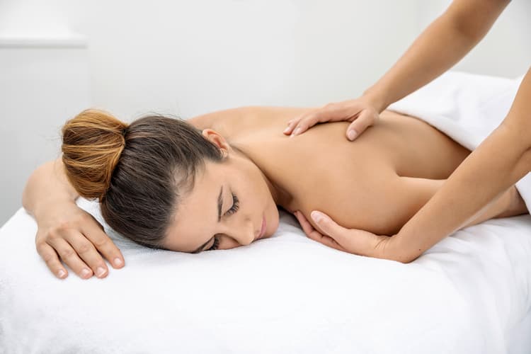 Eine Frau bekommt eine Rückenmassage in der Tamina Therme in der Schweiz.
