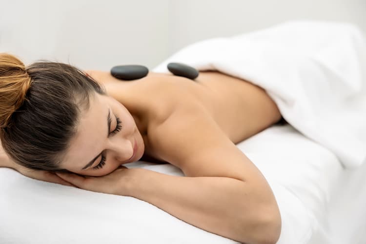 Eine Frau bei einer Hot Stone Massage im Thermalbad Bar Ragaz - Schweiz.