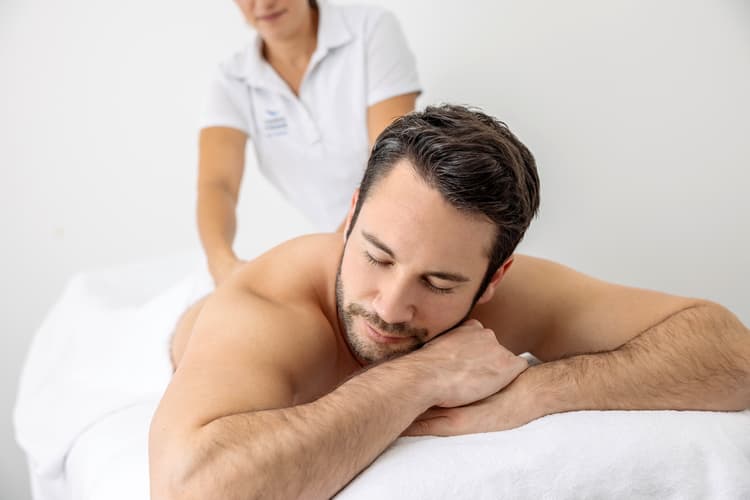 Ein Mann erhält eine Rückenmassage in der Spa Welt der Tamina Therme in Bad Ragaz.