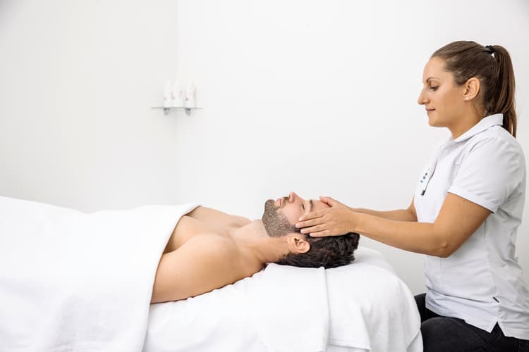 Ein Mann bekommt eine Kopfmassage in der Saunawelt der Tamina Therme.
