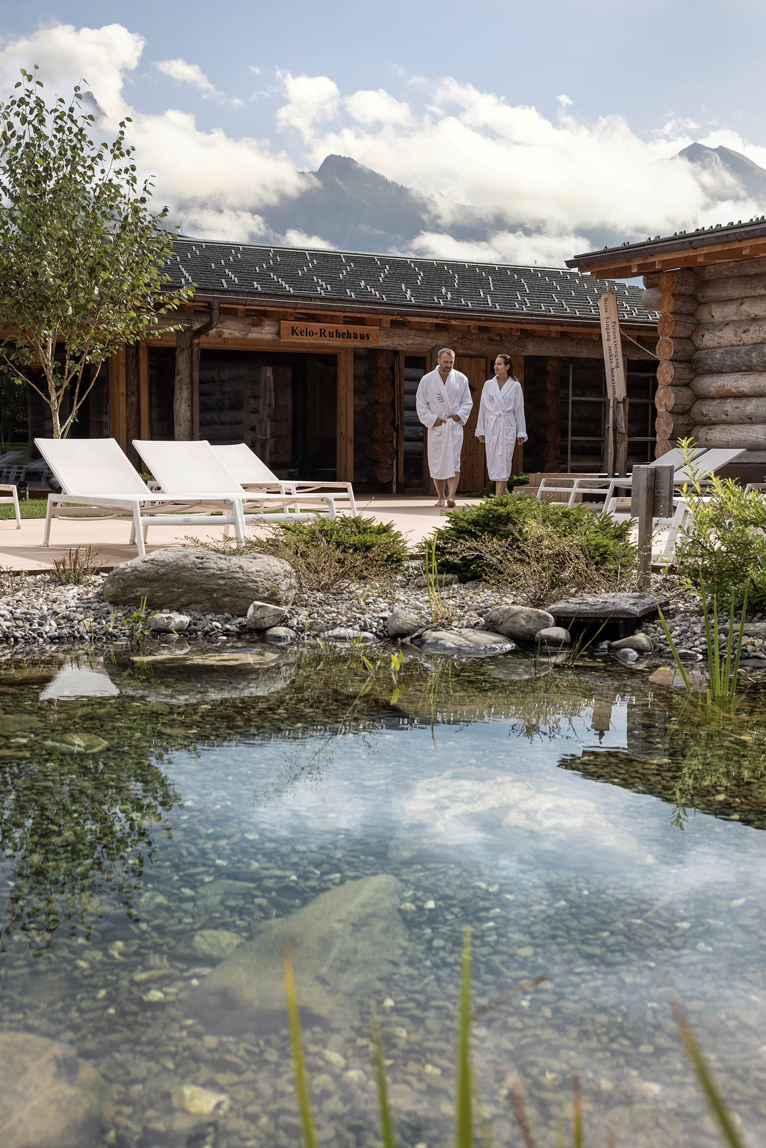 Ein Paar im Bademantel steht am Außenschwimmteich der Tamina Therme in Bad Ragaz.