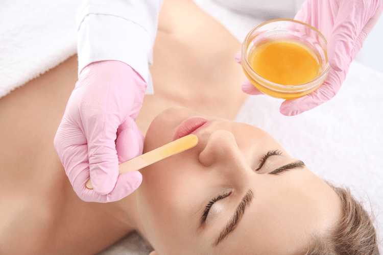 Eine Frau erhält ein Oberlippen Waxing.
