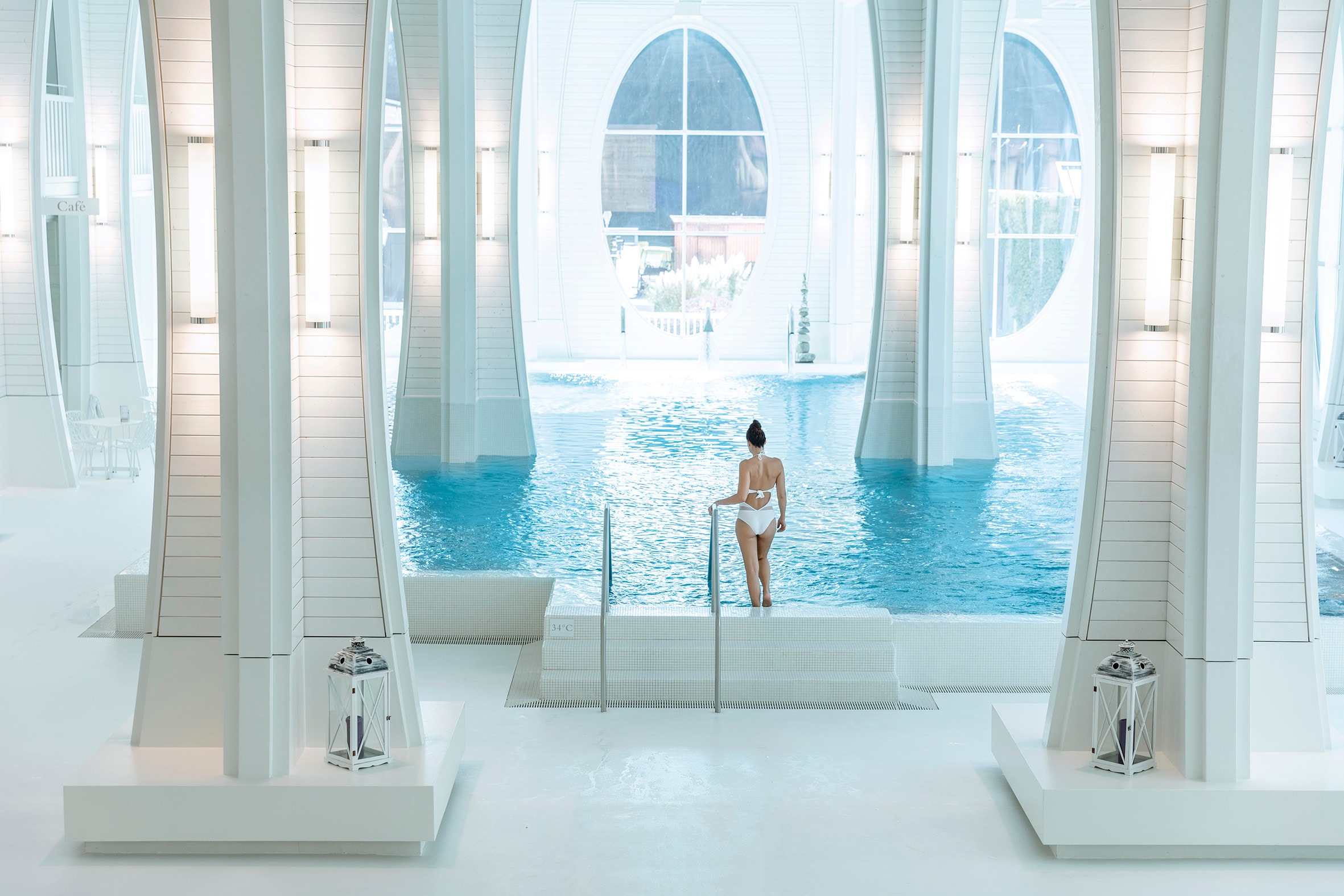 Frau geht über eine Treppe in das Innenbecken der Tamina Therme in der Schweiz.