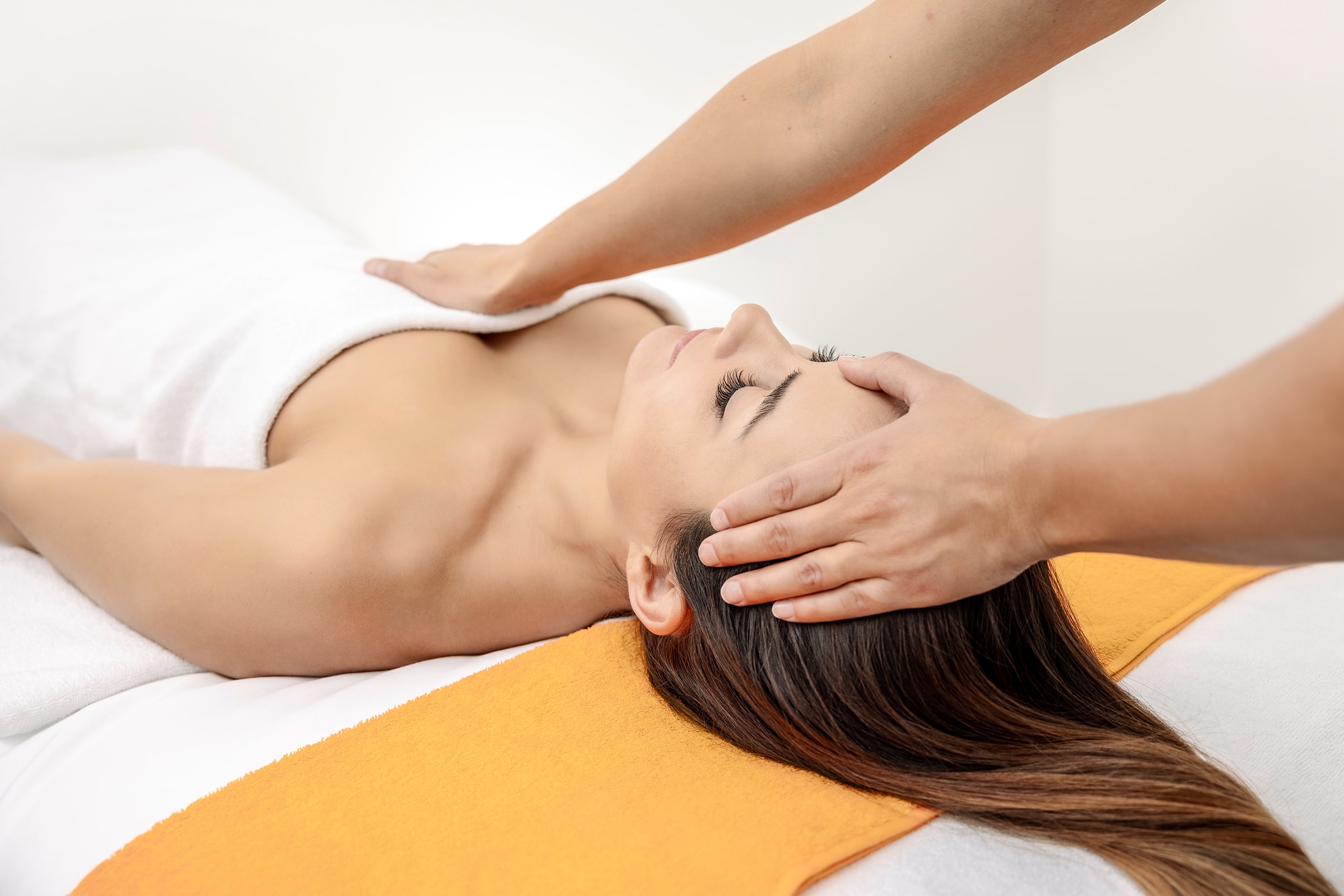 Eine Frau liegt auf einer Massageliege und bekomm ein haki Treatment in der Tamina Therme.