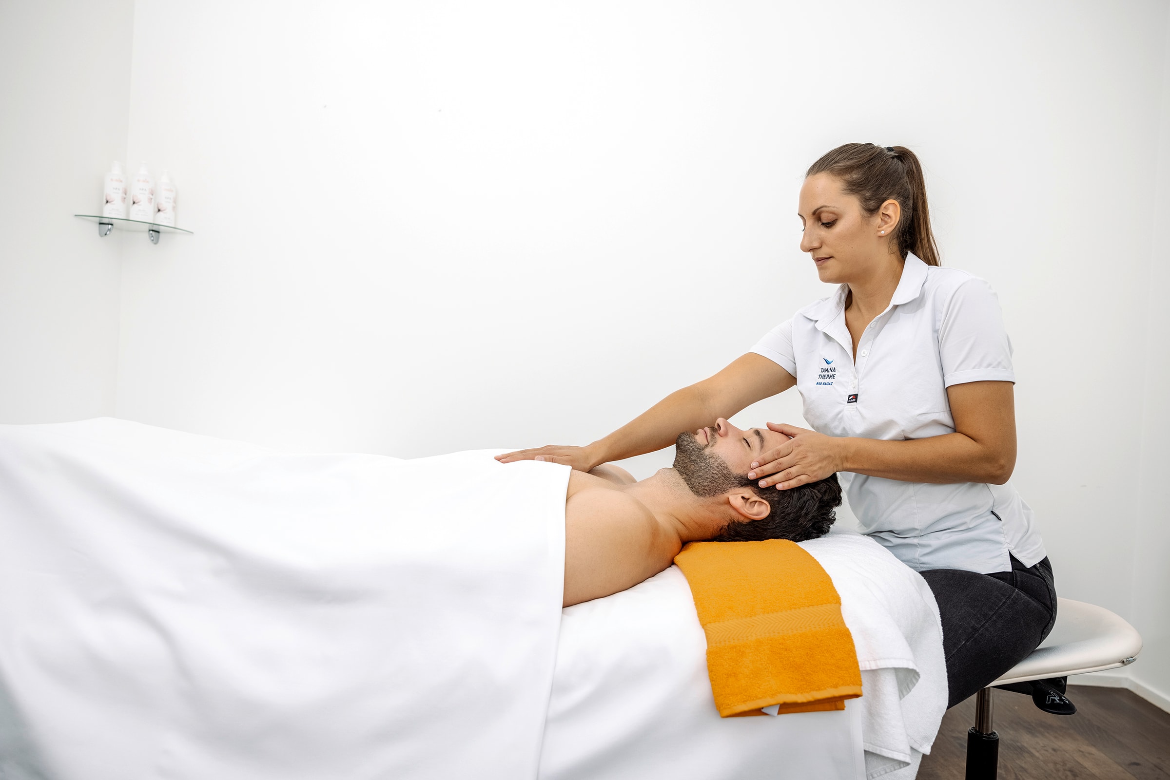 Eine Masseurin führt eine haki Behandlung bei einem Kunden der Tamina Therme durch.
