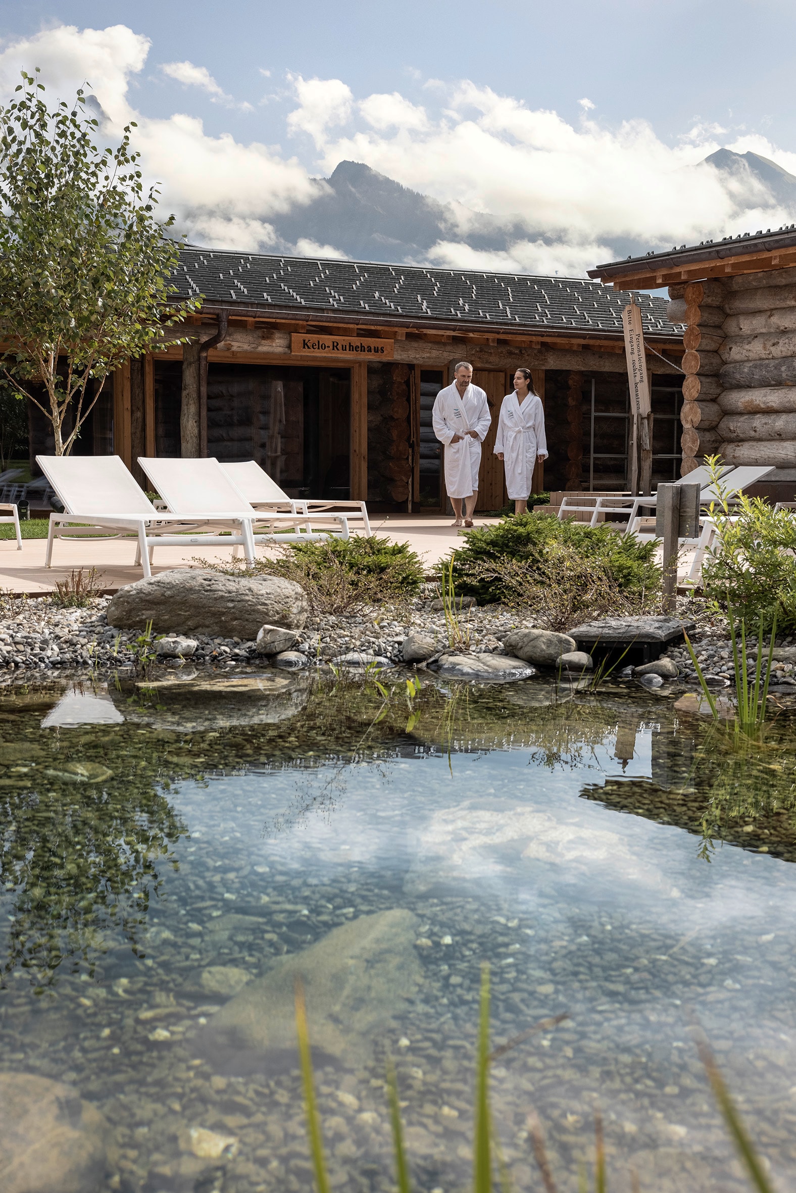 Ein Paar im Bademantel steht am Außenschwimmteich der Tamina Therme in Bad Ragaz.