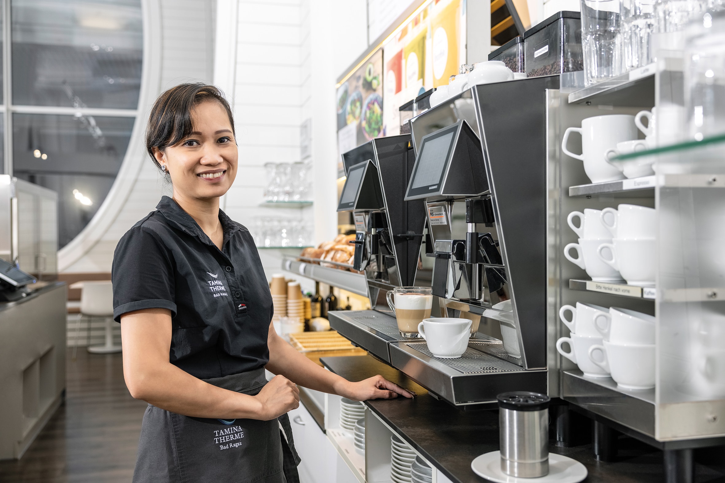 Eine Mitarbeiterin im Café der Tamina Therme bereitet Kaffee zu.