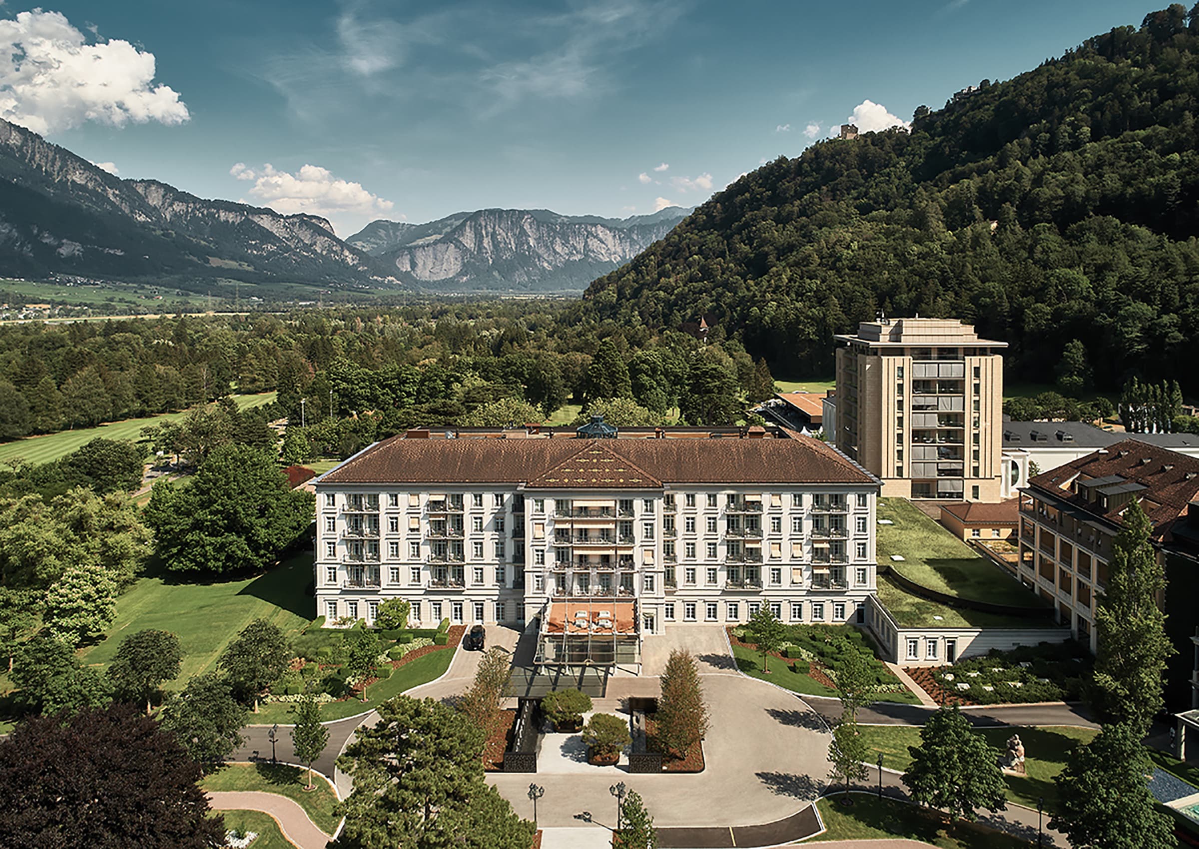 Blick auf das Grand Resort Bad Ragaz und einer grünen Landschaft im Hintergrund.