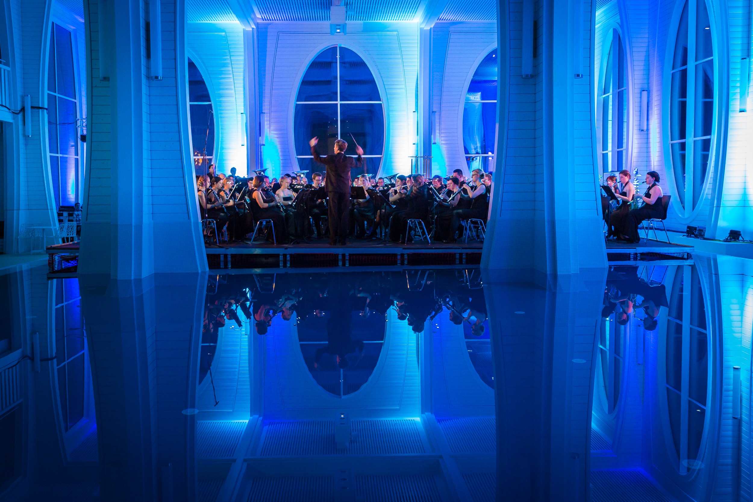 Mehrere Menschen sitzen auf Stühlen und lauschen einem Konzert in der Tamina Therme.