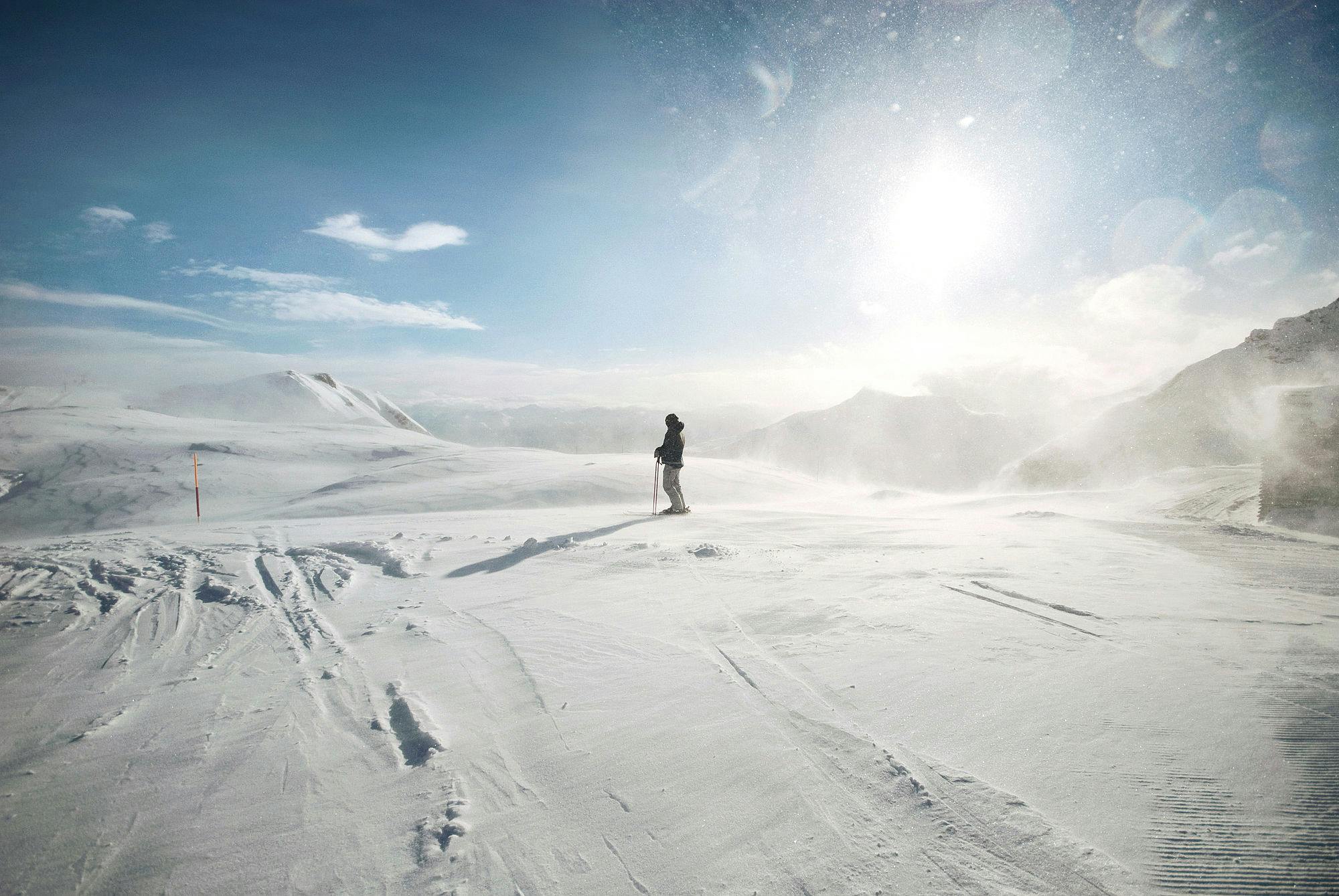 Eine Person steht in einer Schneelandschaft und fährt Ski am Pizol.