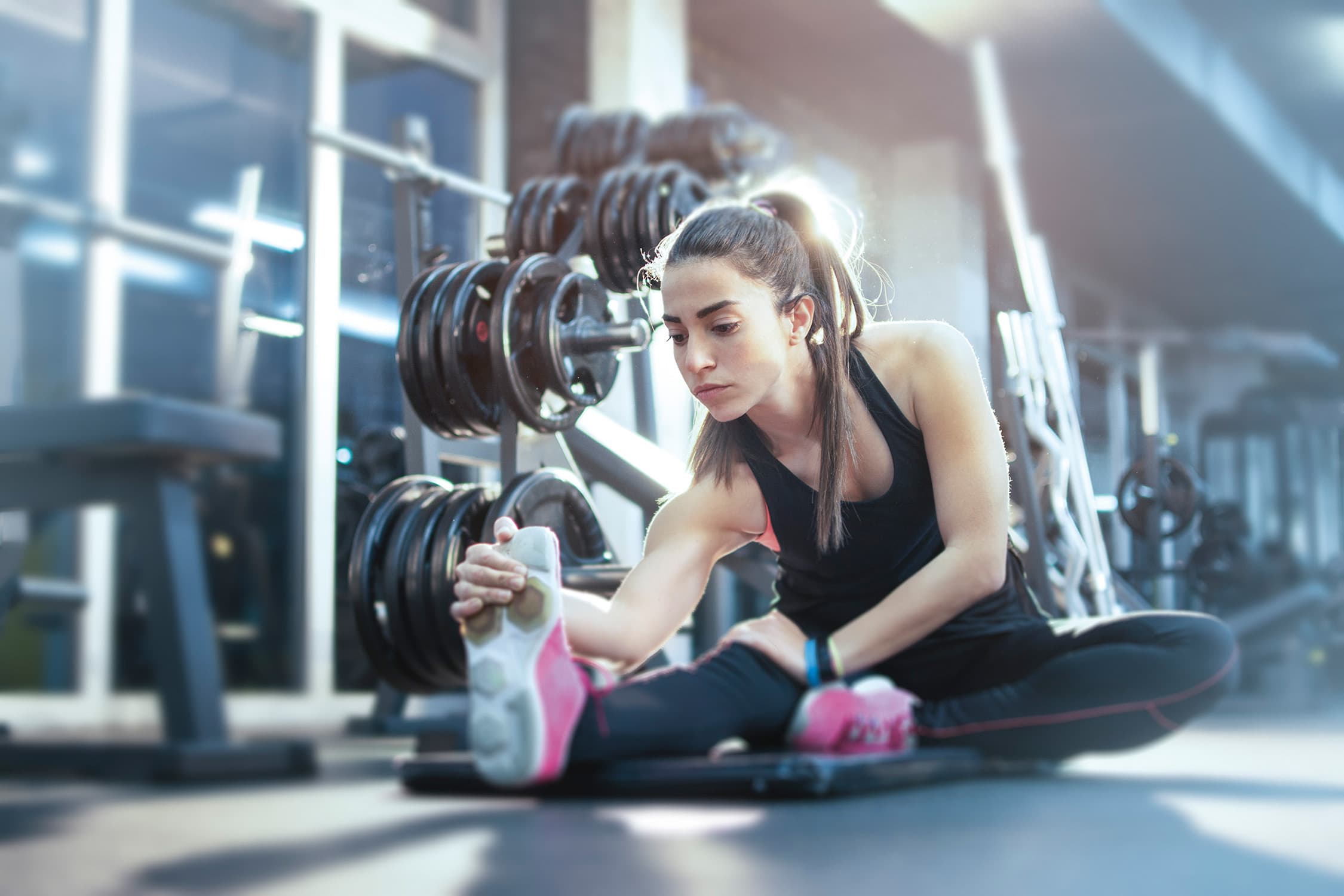 Eine junge Sportlerin dehnt sich im Fitnessraum der Tamina Therme in Bad Ragaz.