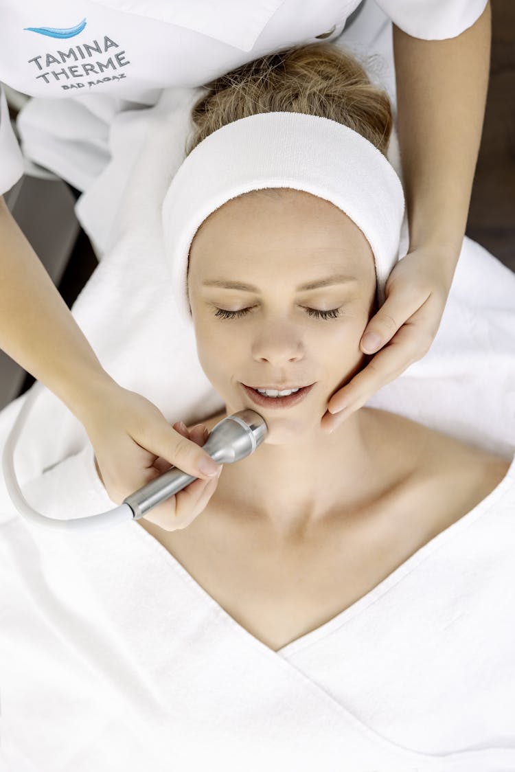 Eine Frau bekommt eine Behandlung mit Ultraschall im Gesicht.