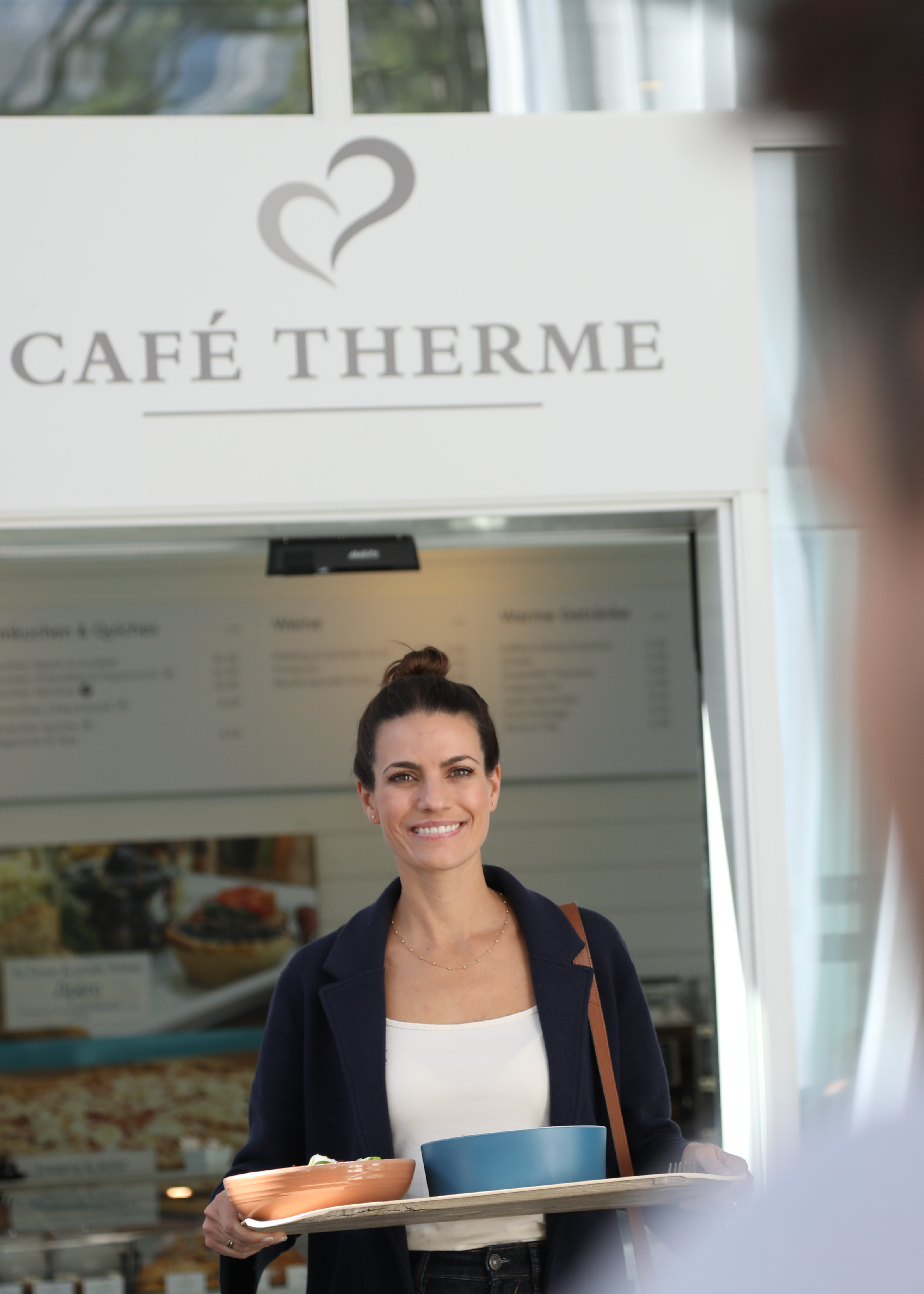 Eine Frau läuft durch den Eingang des Cafés der Tamina Therme.