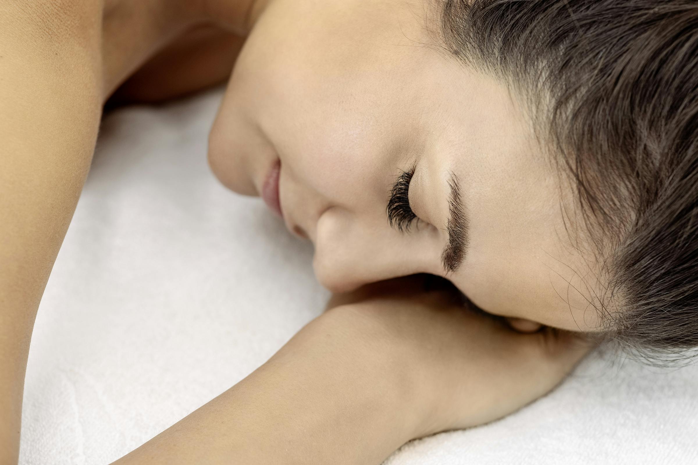 Detailaufnahme Frau legt Kopf auf die Hände während einer Massage im besten Wellnessbad der Schweiz.