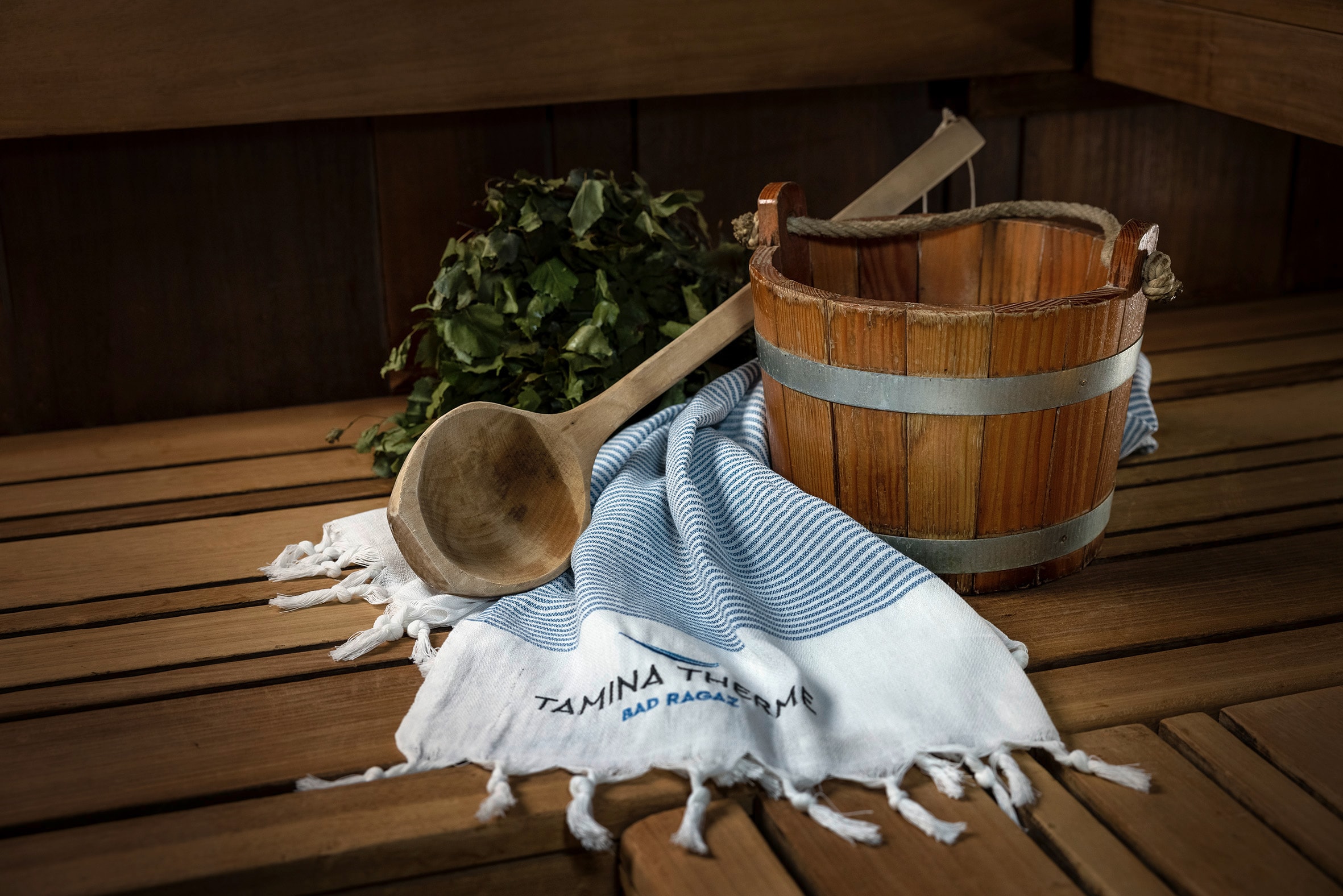 Blick auf eine Sauna Keller und ein Holzeimer gefüllt mit Wasser.