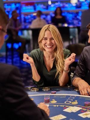 Eine Frau und ein Mann sitzen an einem Pokertisch im Casino Bad Ragaz