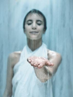 Eine Frau hält ihre Hand unter fließend Wasser.