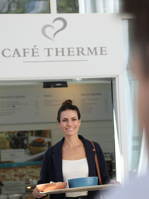 Eine Frau läuft durch den Eingang des Cafés der Tamina Therme.